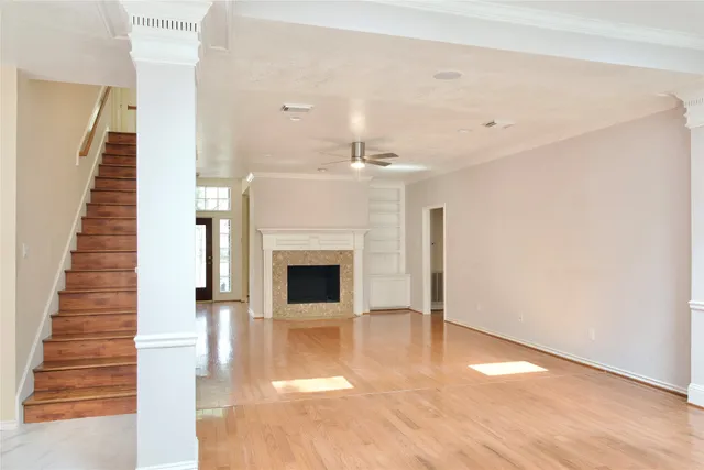 a view of a livingroom with wooden floor and staircase