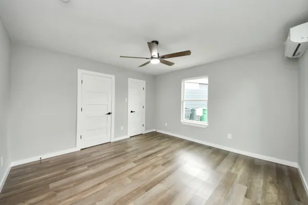 an empty room with wooden floor and windows