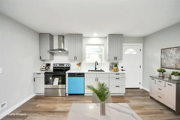 a kitchen with stainless steel appliances kitchen island granite countertop a sink stove and white cabinets