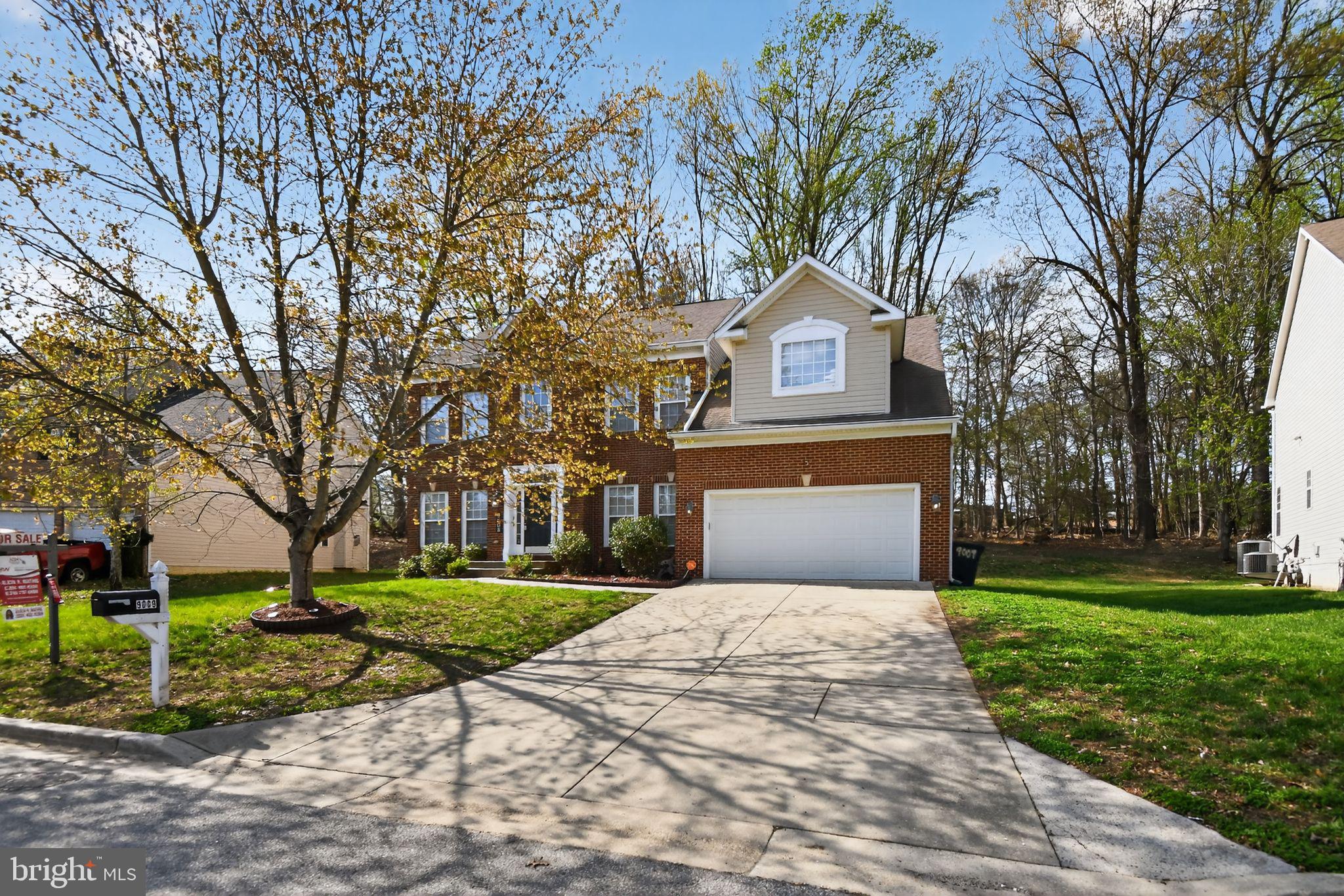 a front view of a house with a yard and trees