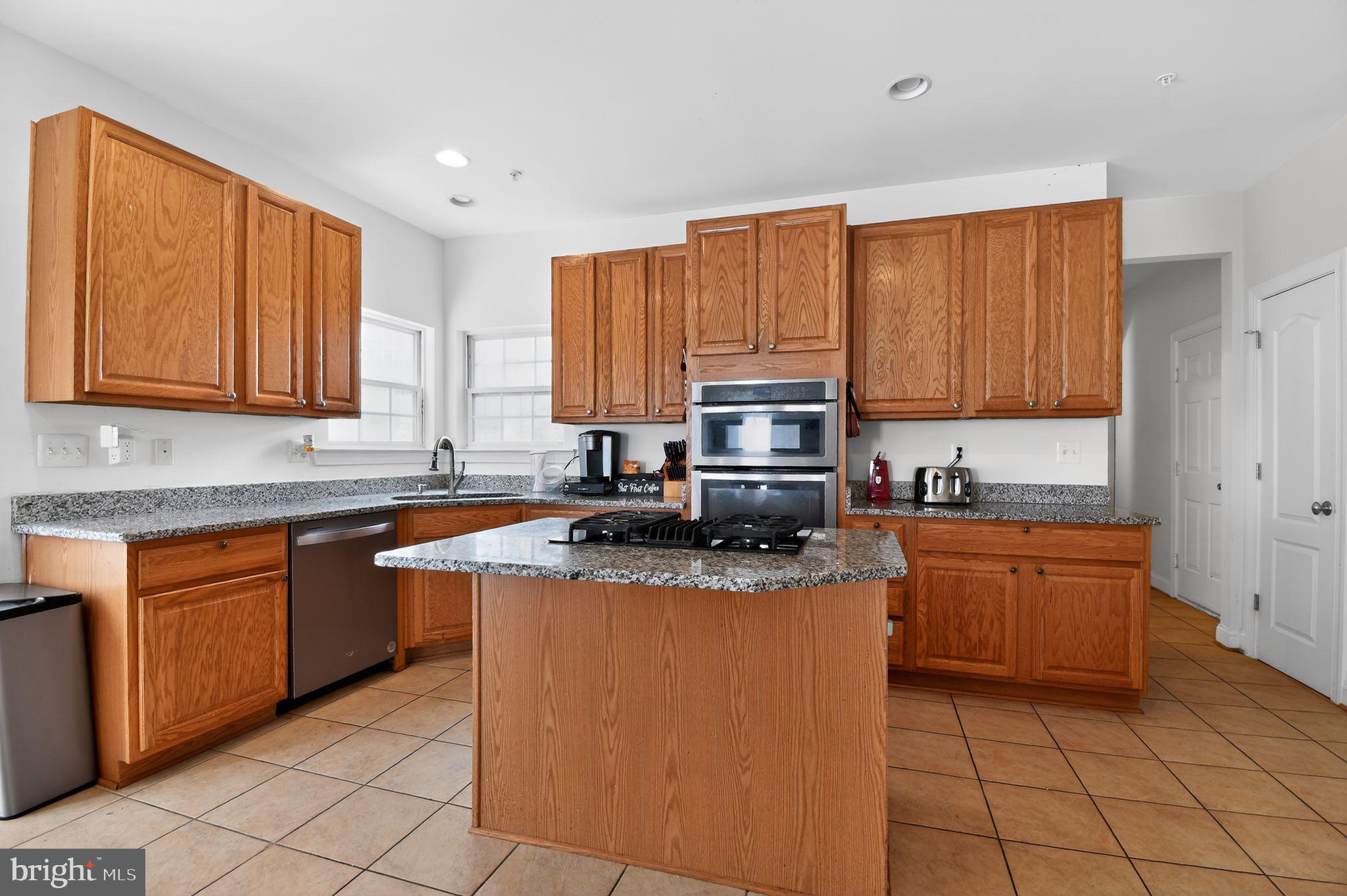 9009 Eldon Drive Clinton, MD 20735 - Photo 15 of 40 a kitchen with stainless steel appliances granite countertop a stove top oven a sink dishwasher and a microwave oven on the blue kitchen countertops