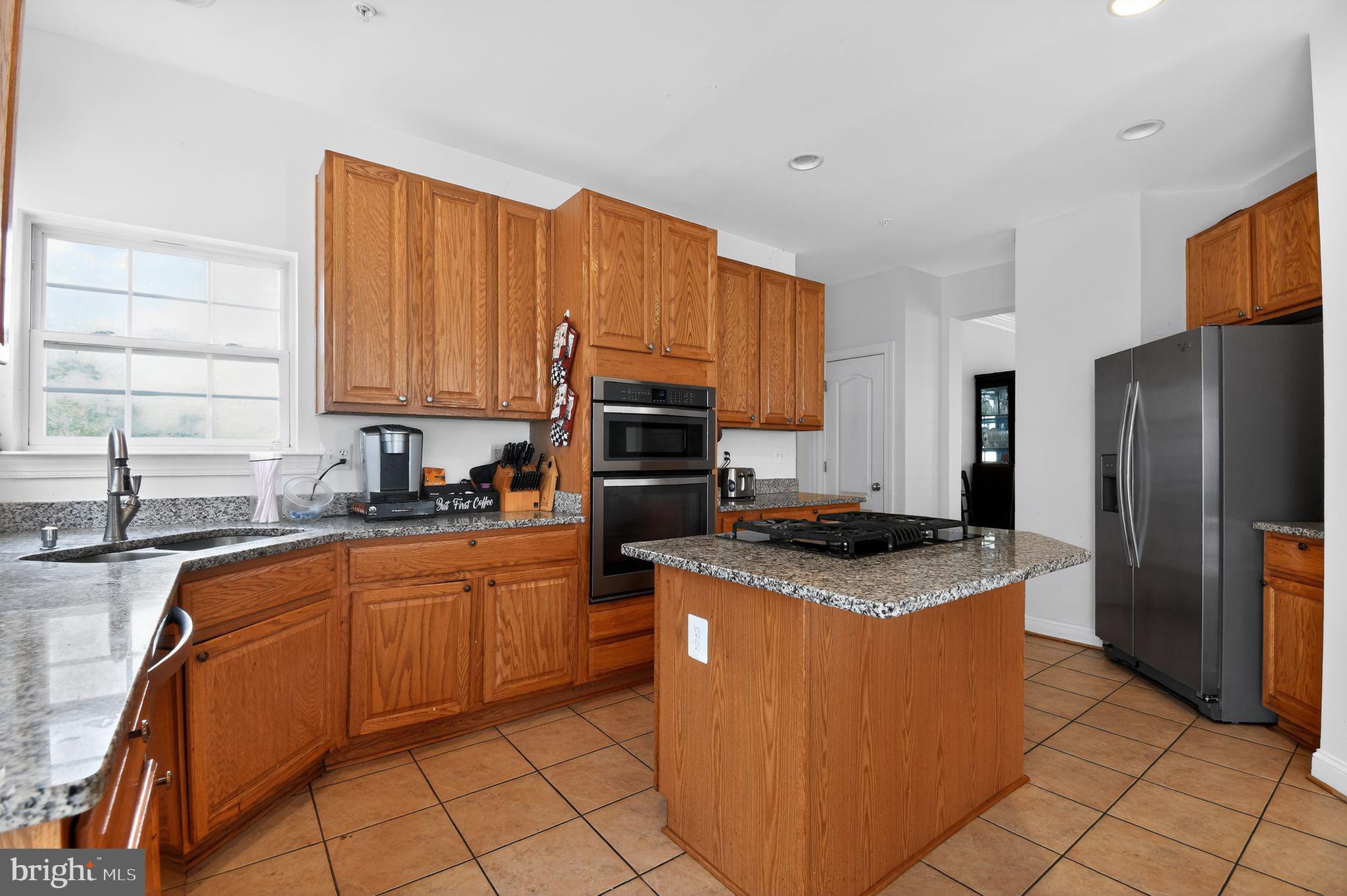 9009 Eldon Drive Clinton, MD 20735 - Photo 16 of 40 a kitchen with stainless steel appliances granite countertop a sink stove refrigerator and cabinets