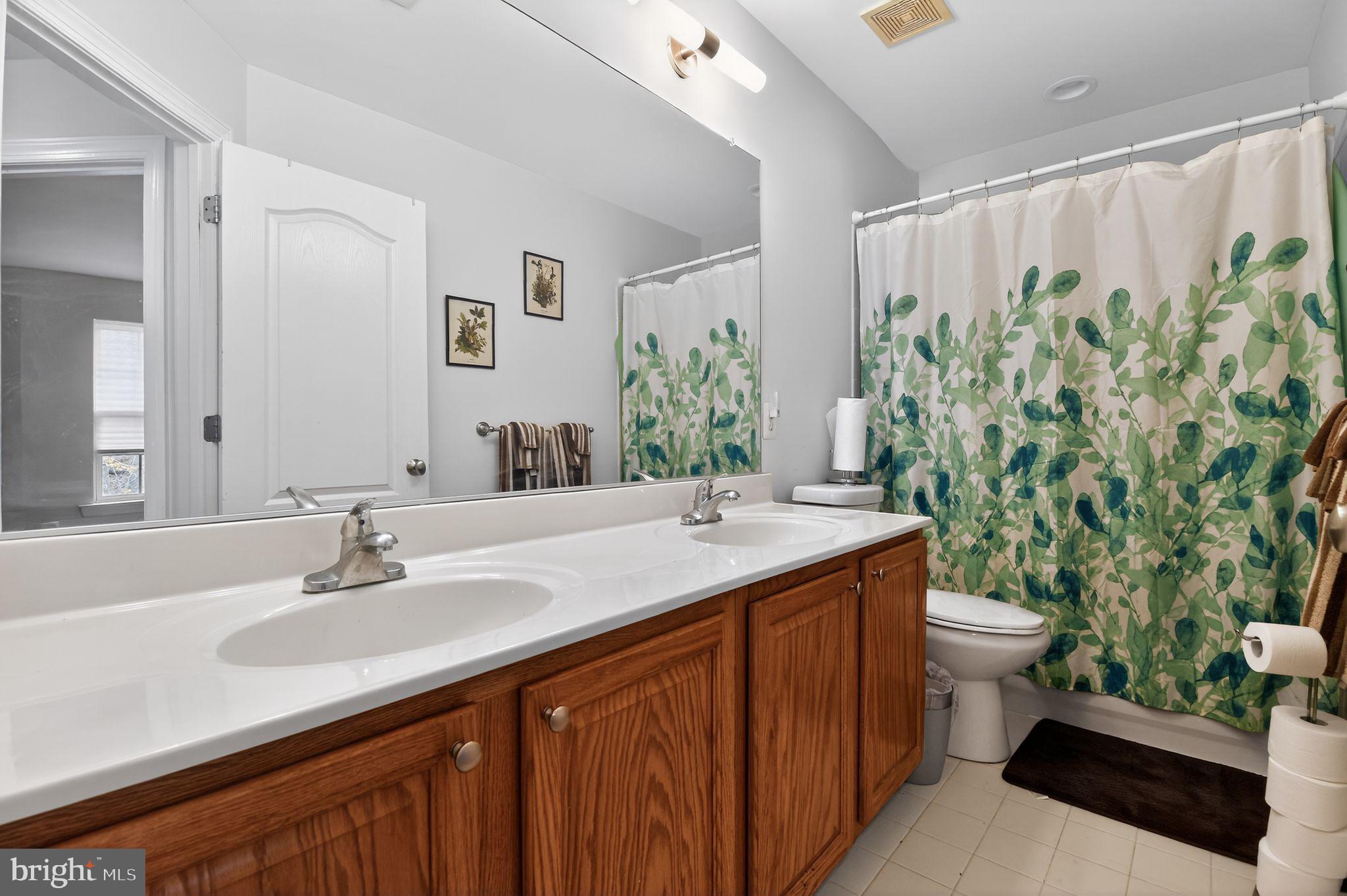 9009 Eldon Drive Clinton, MD 20735 - Photo 28 of 40 a bathroom with a granite countertop sink a toilet and a mirror