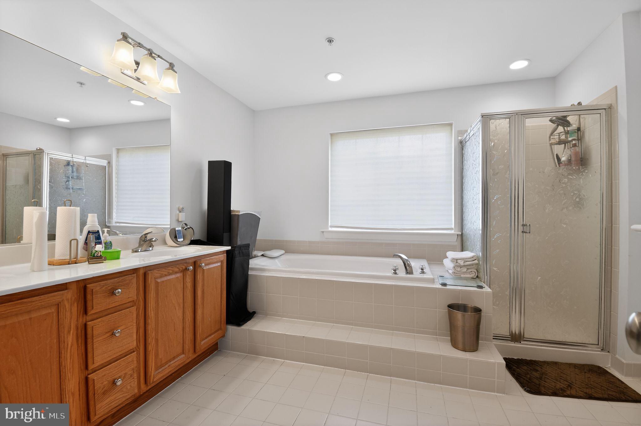 9009 Eldon Drive Clinton, MD 20735 - Photo 30 of 40 a spacious bathroom with a double vanity sink a mirror and a bathtub