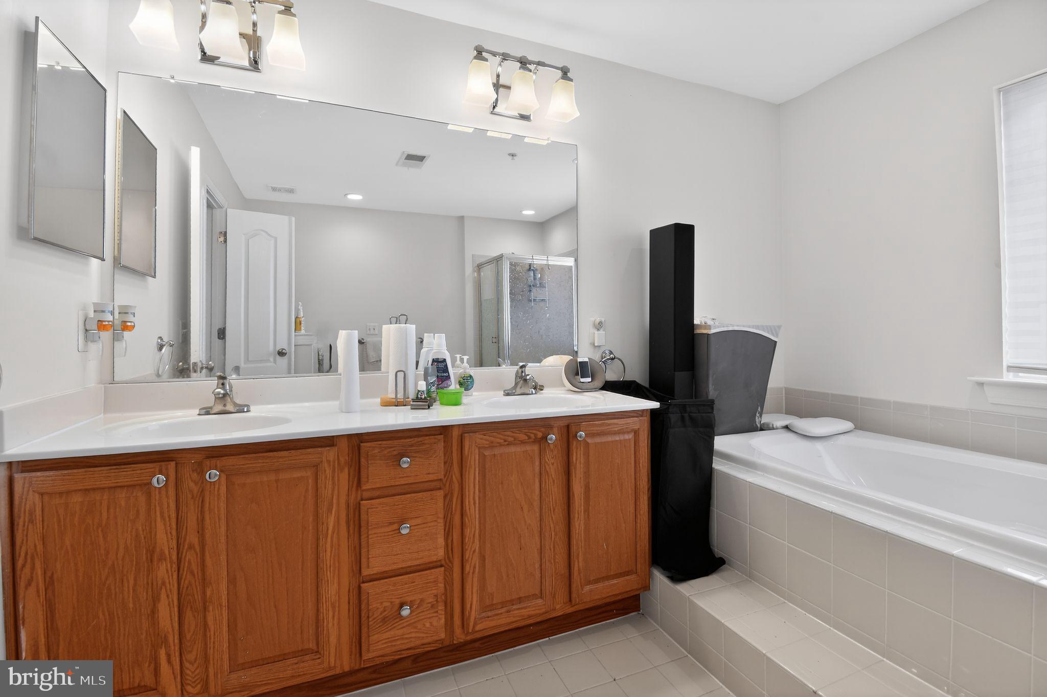 9009 Eldon Drive Clinton, MD 20735 - Photo 32 of 40 a bathroom with a sink double vanity granite tub and a mirror