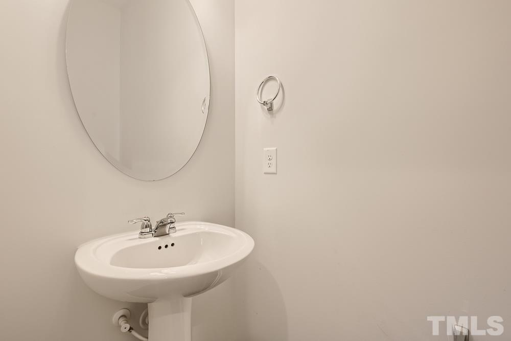 2557 Rambling Creek Road Apex, NC 27523 - Photo 11 of 27 a bathroom with a sink a mirror and a toilet