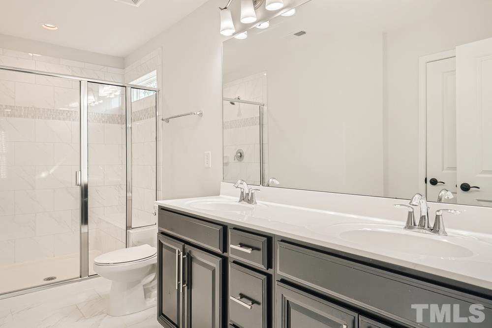 2557 Rambling Creek Road Apex, NC 27523 - Photo 15 of 27 a bathroom with a sink and a mirror