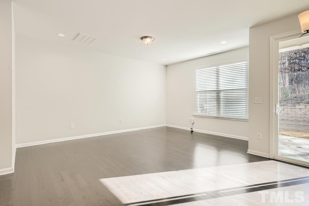 2557 Rambling Creek Road Apex, NC 27523 - Photo 5 of 27 an empty room with wooden floor and windows