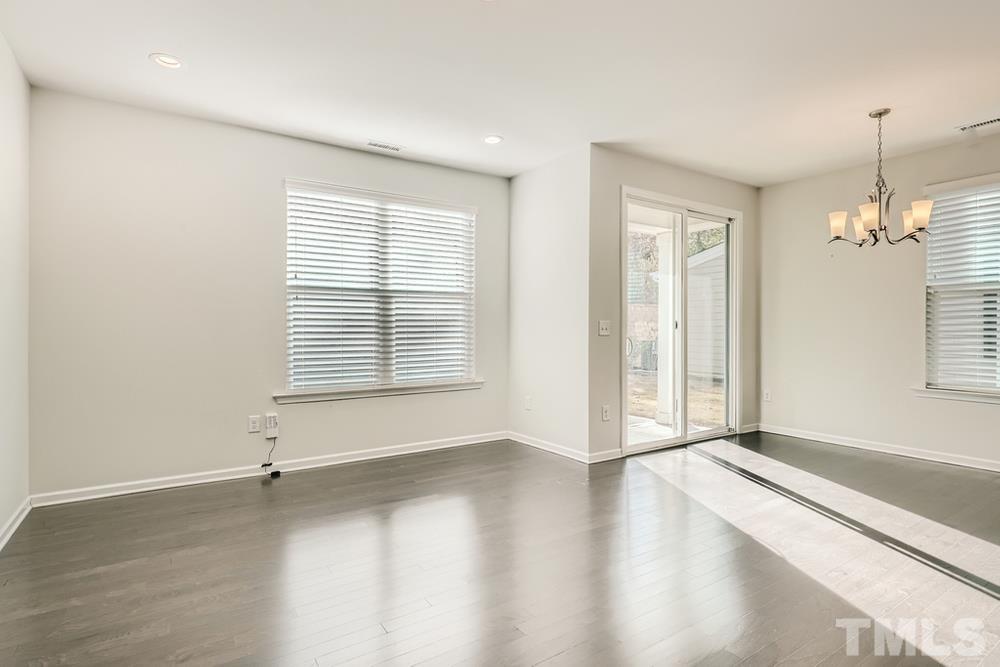 2557 Rambling Creek Road Apex, NC 27523 - Photo 6 of 27 an empty room with wooden floor and windows