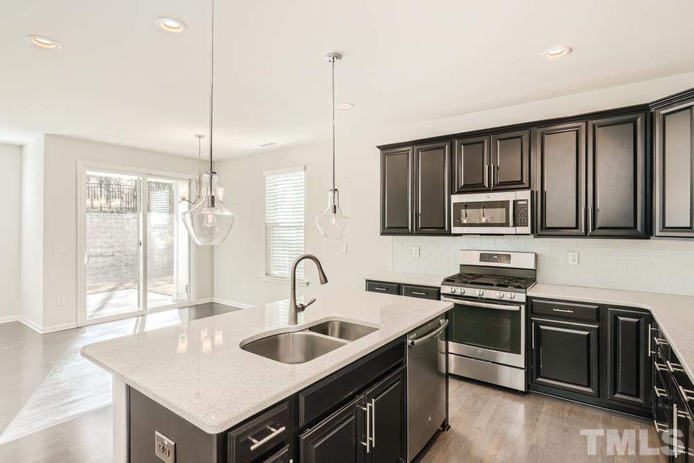2557 Rambling Creek Road Apex, NC 27523 - Photo 7 of 27 a kitchen with stainless steel appliances a sink stove and microwave