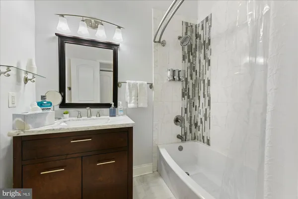 a bathroom with a bathtub sink and mirror