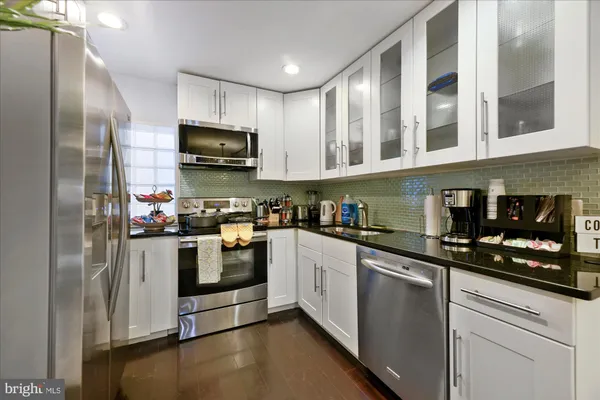 a kitchen with stainless steel appliances granite countertop a stove a sink and a refrigerator