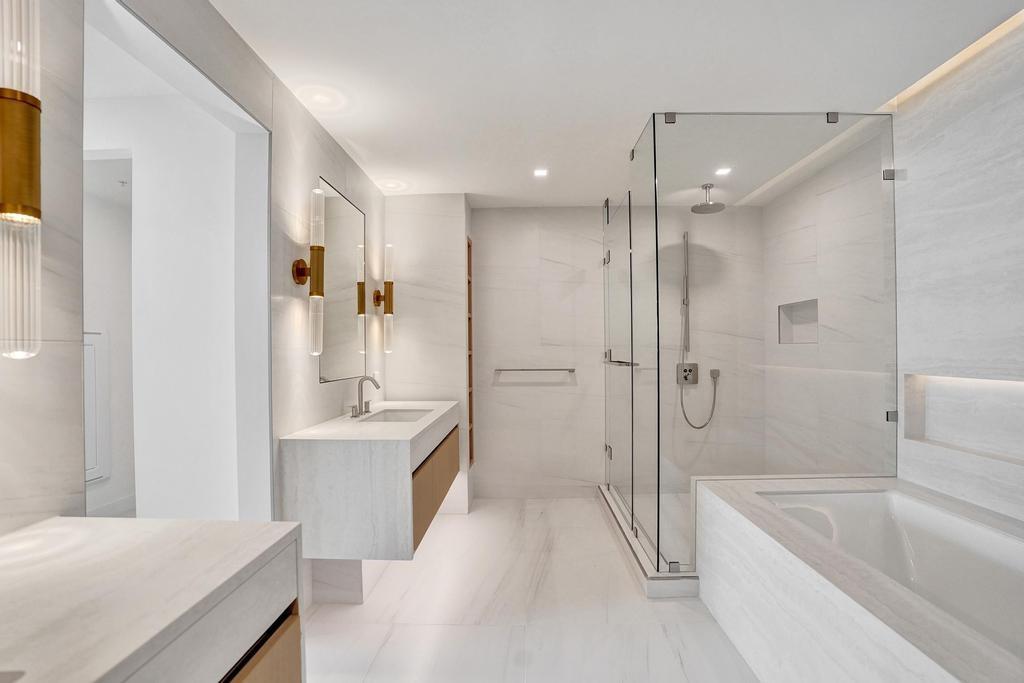 900 North Ocean Boulevard, Unit 1405 Pompano Beach, FL 33062 - Photo 20 of 59 a bathroom with a tub sink shower and mirror