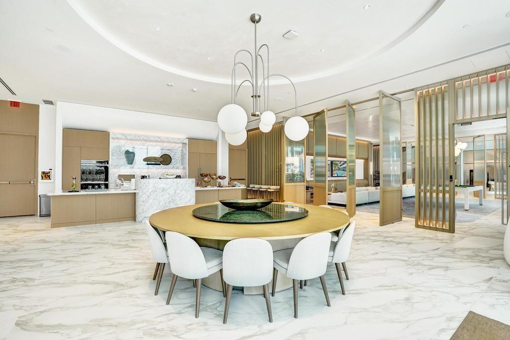 900 North Ocean Boulevard, Unit 1405 Pompano Beach, FL 33062 - Photo 45 of 59 a dining room with wooden floor a chandelier a wooden table and chairs