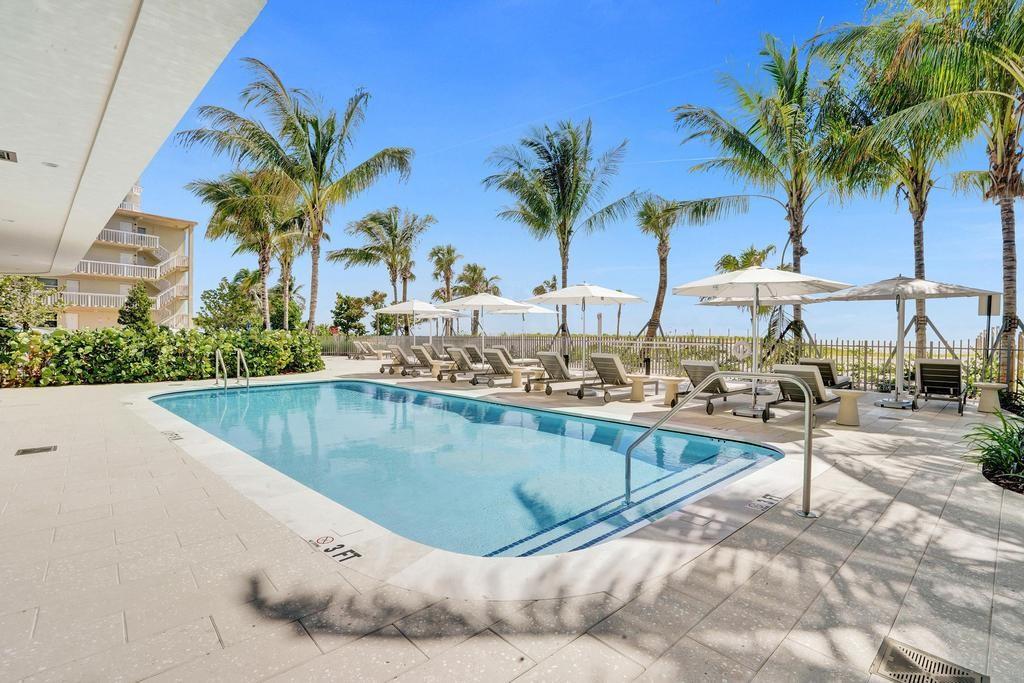 900 North Ocean Boulevard, Unit 1405 Pompano Beach, FL 33062 - Photo 54 of 59 a view of a swimming pool with a lawn chairs under palm trees