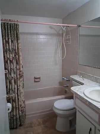 a bathroom with a shower a toilet and sink