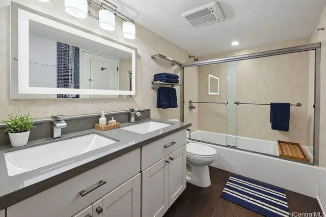 a bathroom with a granite countertop sink toilet and shower