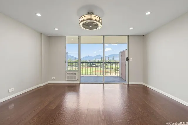 an empty room with wooden floor and a large window