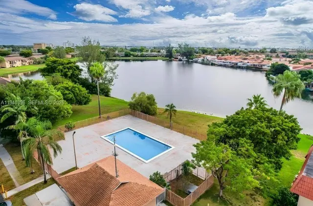 an aerial view of a house with a yard and lake view