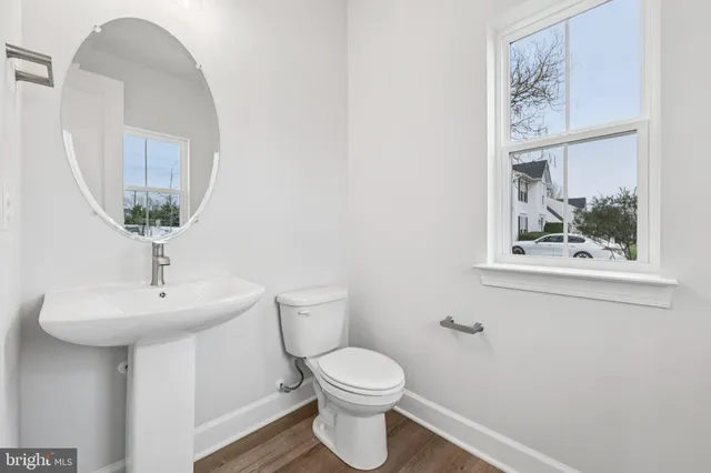 a bathroom with a toilet a sink and mirror