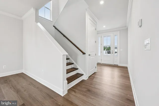 a view of entryway and hall with wooden floor