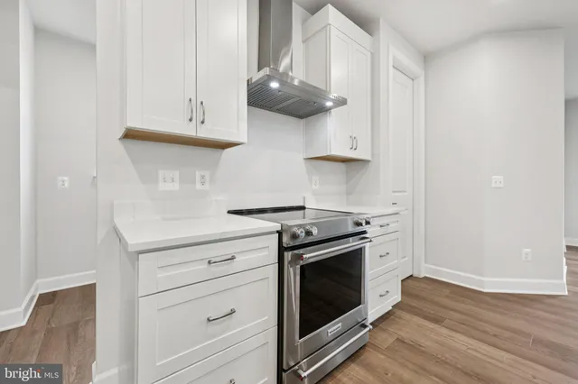a kitchen with white cabinets and a stove