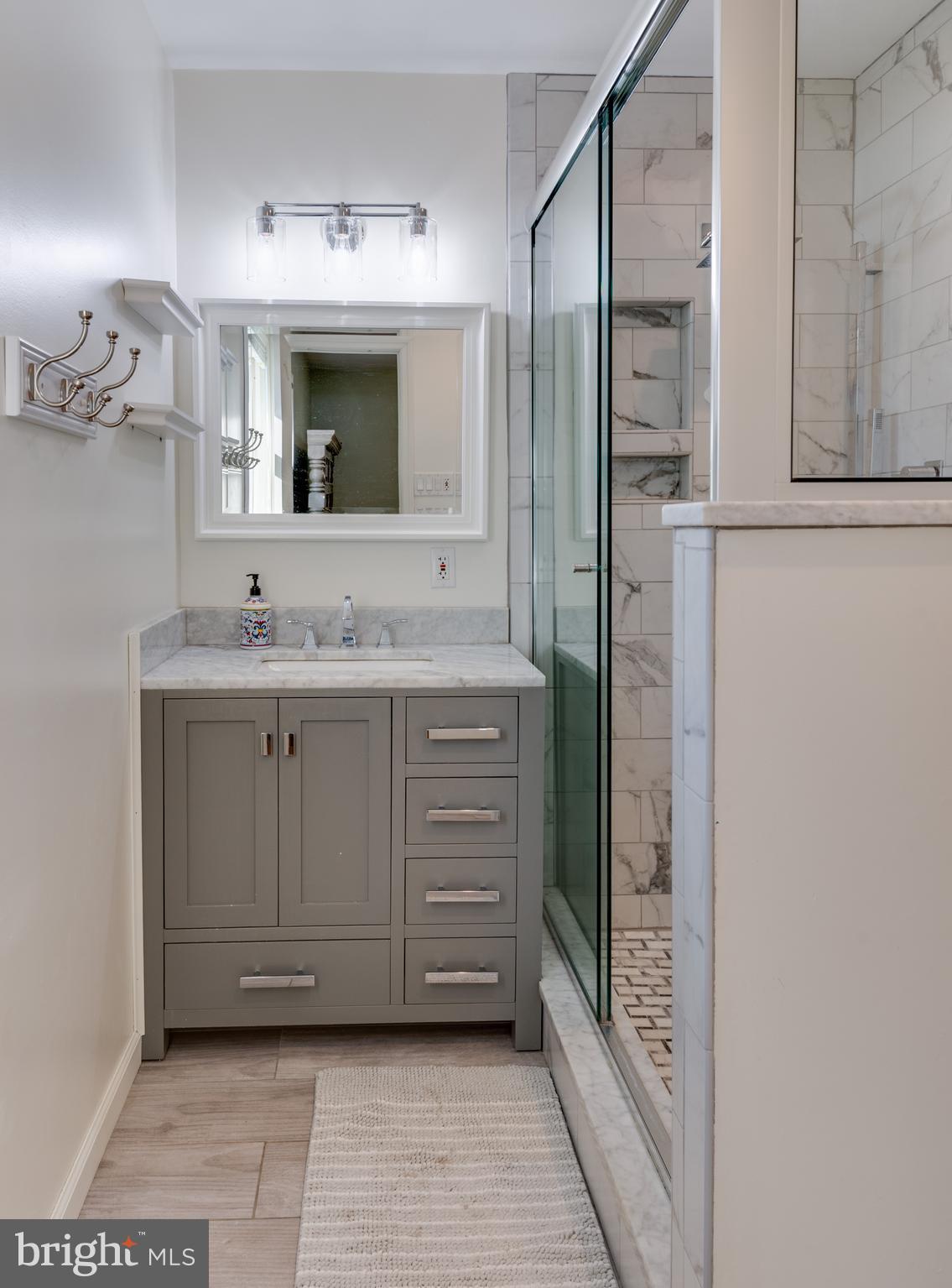 44125 Louisdale Road California, MD 20619 - Photo 19 of 44 a bathroom with a sink a mirror and a shower