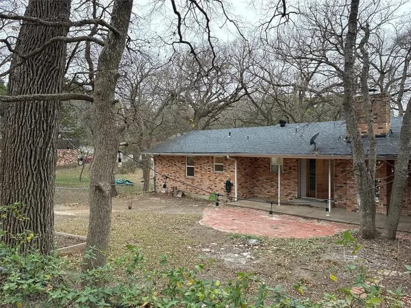 a front view of a house with a yard and tree s