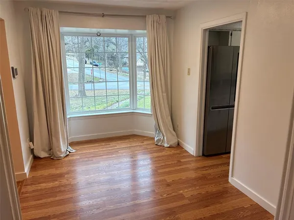 an empty room with wooden floor and a window