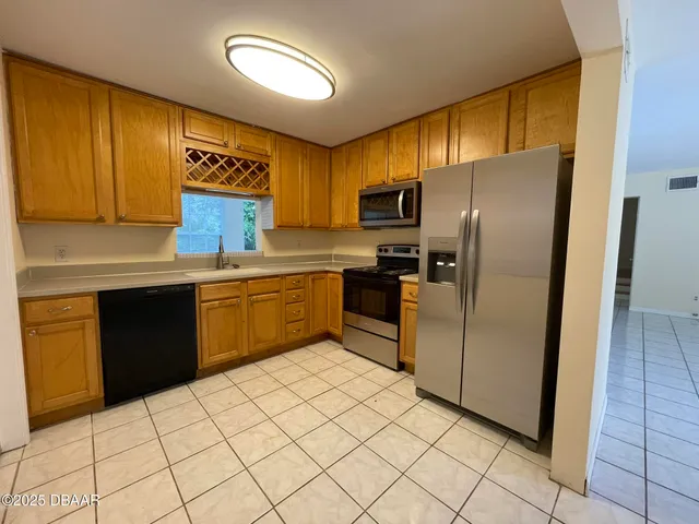 a kitchen with stainless steel appliances a refrigerator sink and cabinets