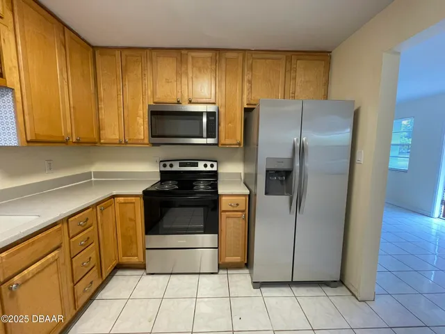 a kitchen with stainless steel appliances granite countertop a refrigerator and a stove top oven
