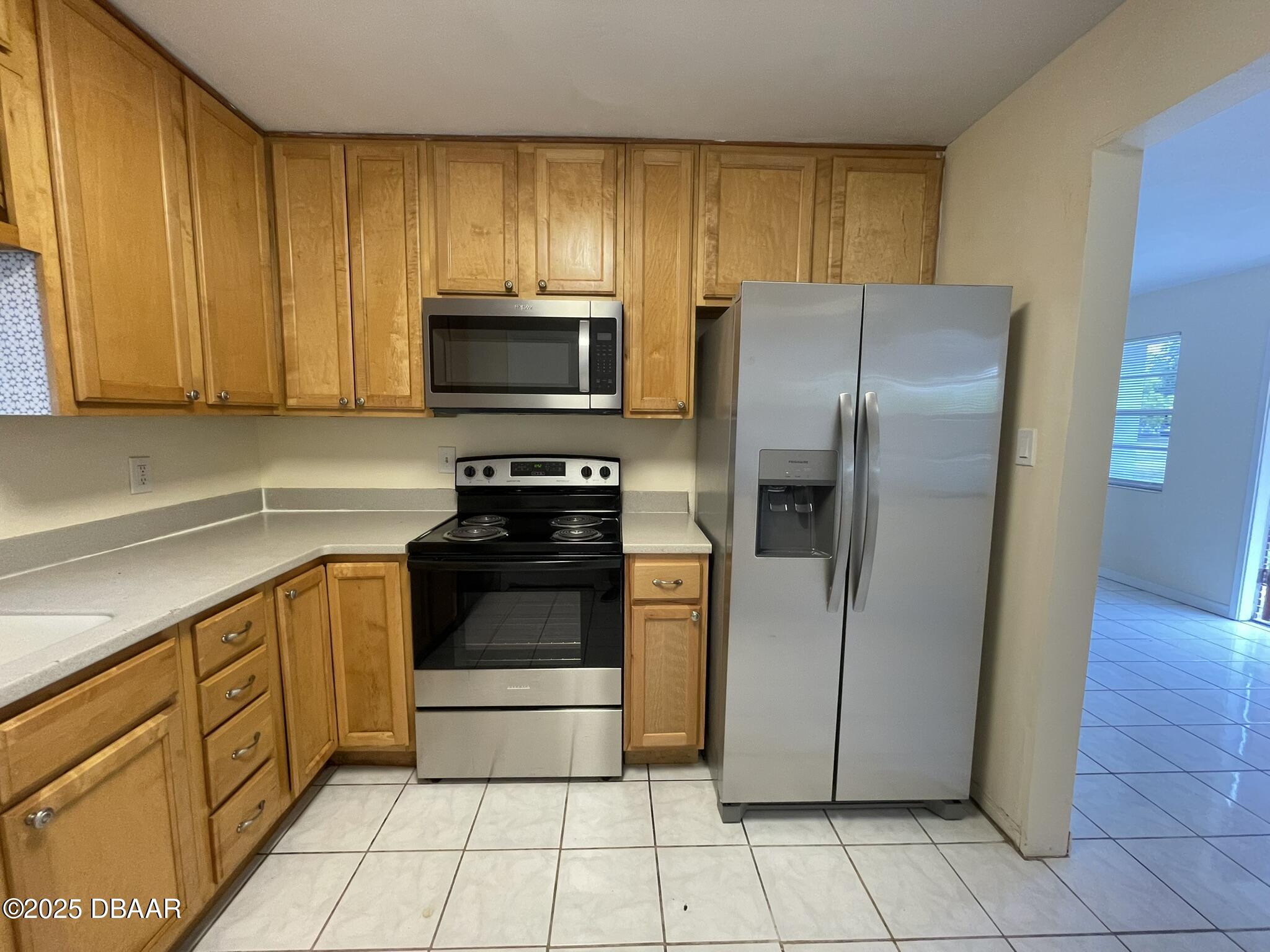 525 Tarragona Way Daytona Beach, FL 32114 - Photo 13 of 47 a kitchen with stainless steel appliances granite countertop a refrigerator and a stove top oven