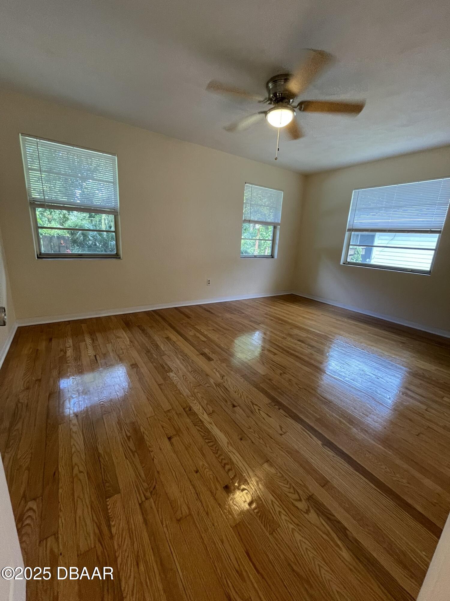 525 Tarragona Way Daytona Beach, FL 32114 - Photo 23 of 47 wooden floor in an empty room with a window