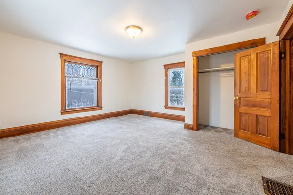 an empty room with windows and closet