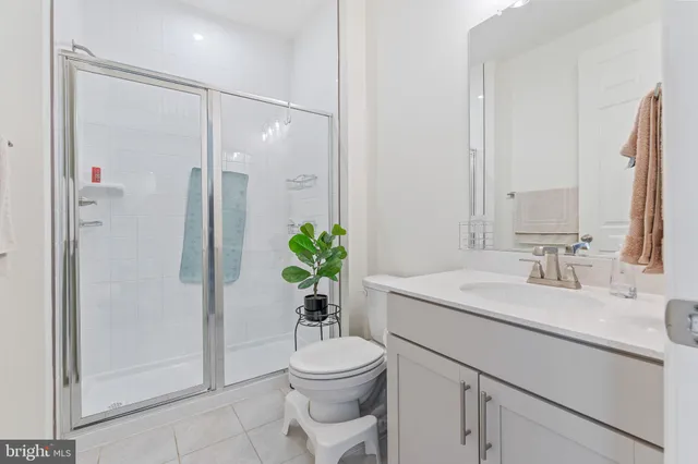 a bathroom with a granite countertop sink toilet a large mirror and shower