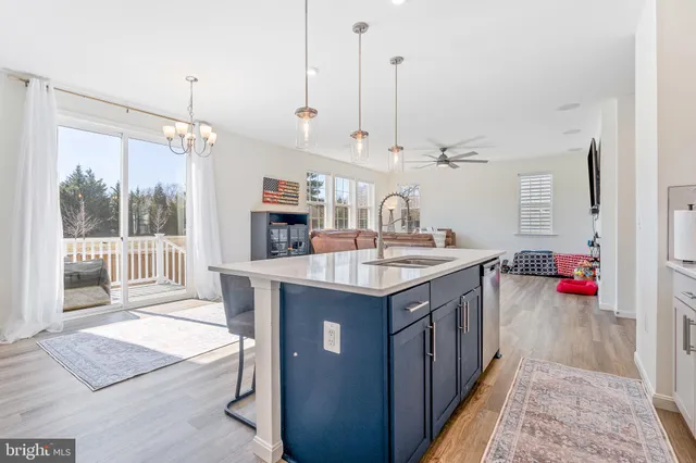 a kitchen with kitchen island a sink stove and wooden floor