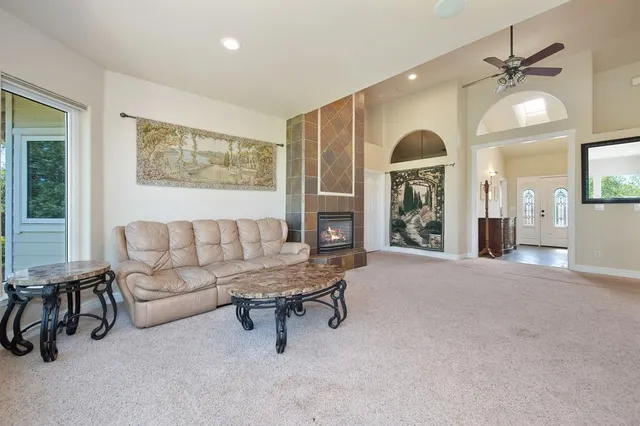 a kitchen with stainless steel appliances granite countertop a refrigerator a sink a dining table and chairs with wooden floor