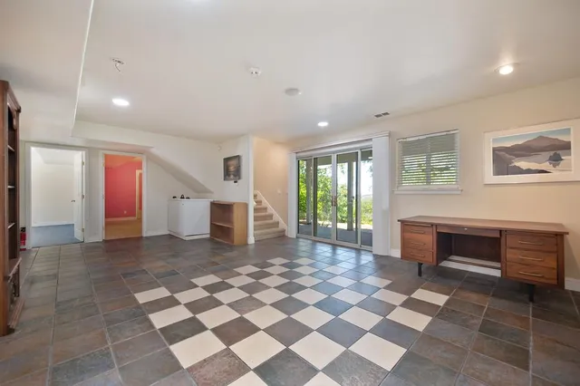 a backyard of a house with large trees and plants