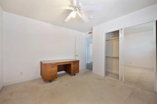 a view of a small house with a tree in the background