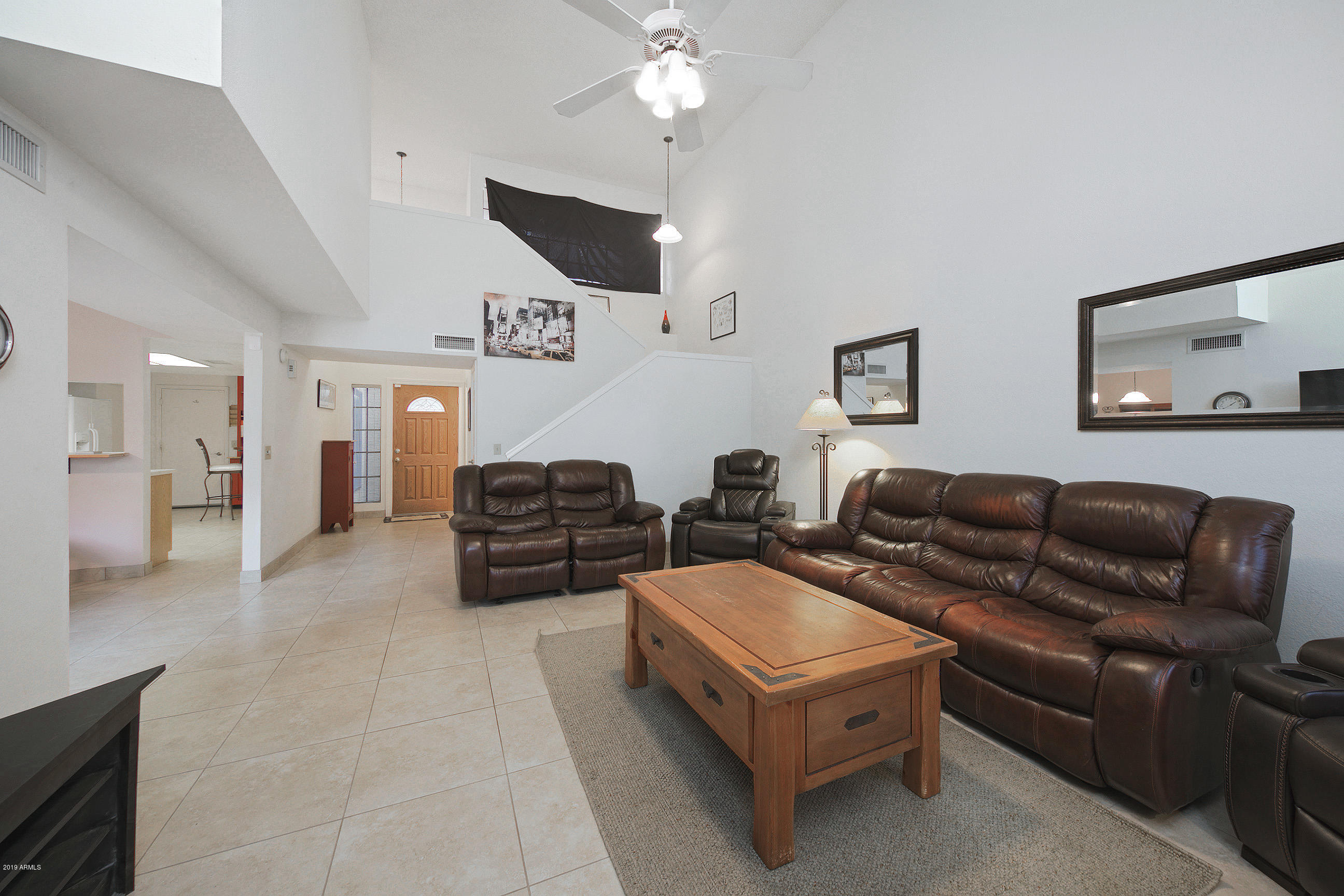 4217 East Agave Road Phoenix, AZ 85044 - Photo 5 of 20 a living room with furniture and a chandelier