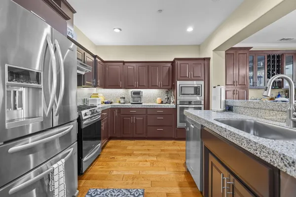 a kitchen with stainless steel appliances granite countertop a sink stove and refrigerator