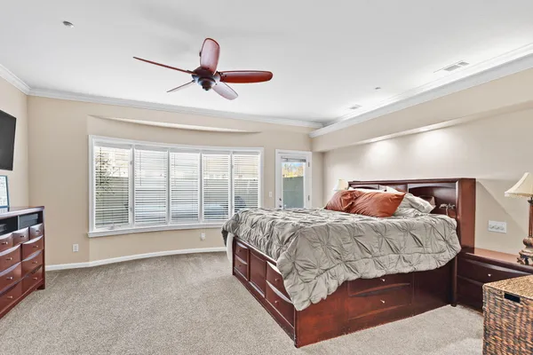 a bedroom with a bed and a large window