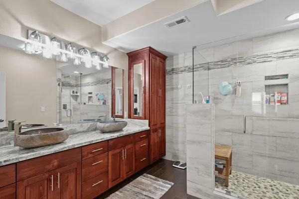 a bathroom with a granite countertop sink a mirror and shower