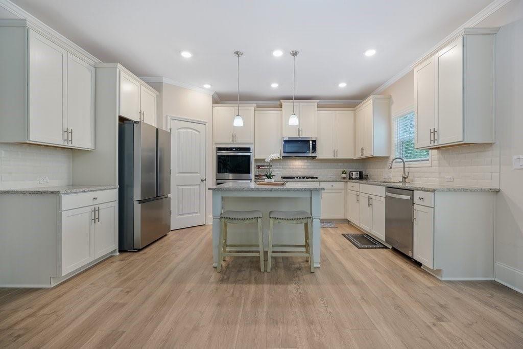 66 Snowdon Way Villa Rica, GA 30180 - Photo 14 of 52 a kitchen with a refrigerator a white cabinets and wooden floor