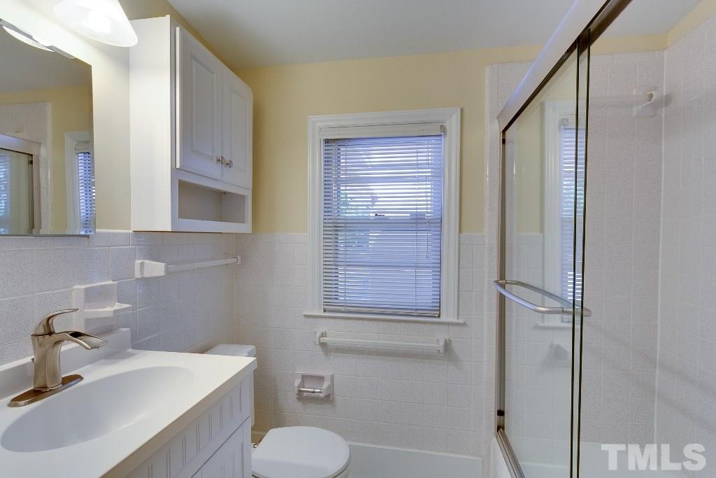 5401 Couch Mountain Road Durham, NC 27705 - Photo 19 of 25 Adjacent to bedrooms two and three is the second full bath with updated fixtures and lighting. All tile and glass for a long lasting clean and durable bathroom.