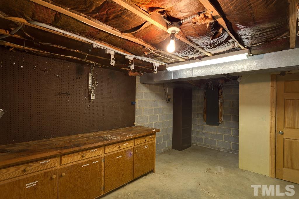 5401 Couch Mountain Road Durham, NC 27705 - Photo 23 of 25 This is a second basement storage / workshop area that is under the master suite. This area has a covered porch entry and has a window, lighting, workbench and closet.