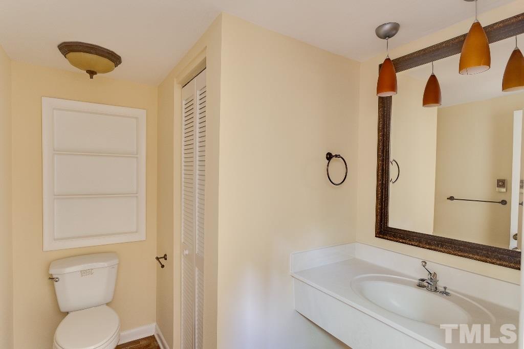 5401 Couch Mountain Road Durham, NC 27705 - Photo 5 of 25 The half bath in the entry foyer has brick floors, extra storage and is nicely updated.