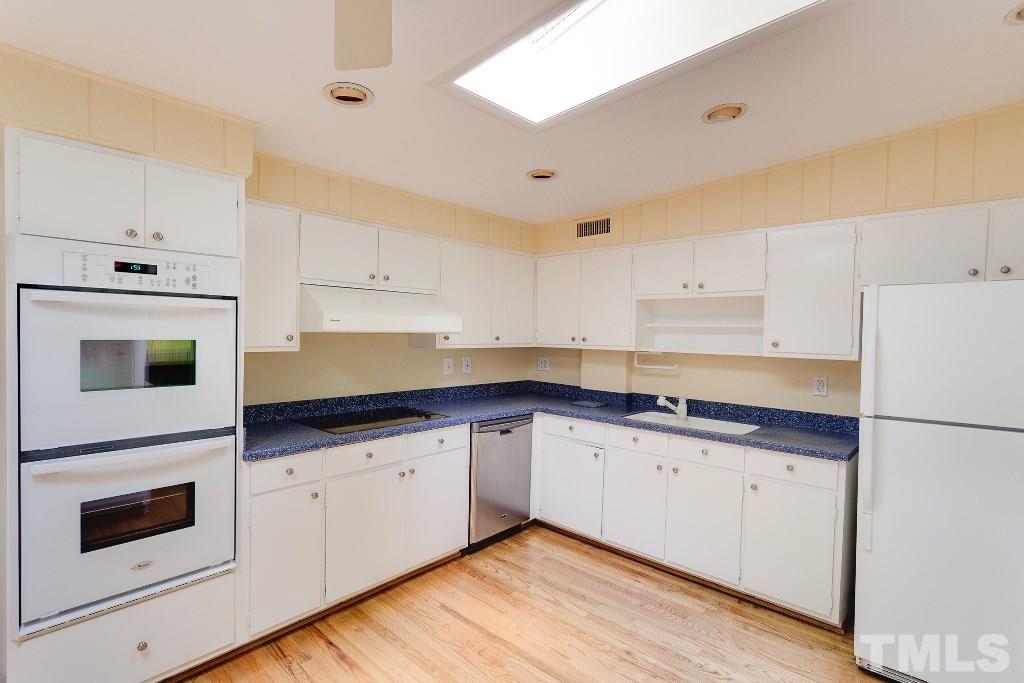 5401 Couch Mountain Road Durham, NC 27705 - Photo 6 of 25 Down the main hall and on the left is the kitchen with loads of natural light from above, solid wood cabinets, and lots of storage. Solid surface counters and lots of functional space are here.