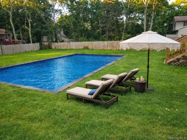 a view of a park with lawn chairs under an umbrella