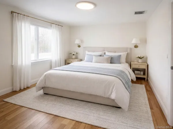 a large bed sitting in a bedroom next to a window